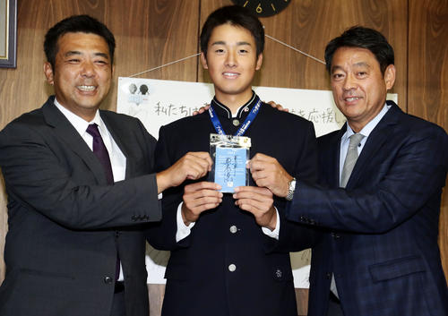 巨人1位指名の青森山田・堀田（中央）は、ドラフト会議の原監督直筆サインが入ったIDを手に、柏田スカウト（左）、長谷川スカウト部長と共に笑顔を見せる（撮影・浅見桂子）