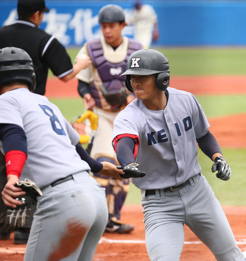慶大対明大　1回表慶大1死二塁、中越え2点本塁打を放ちタッチを交わす柳町（右）（撮影・足立雅史）