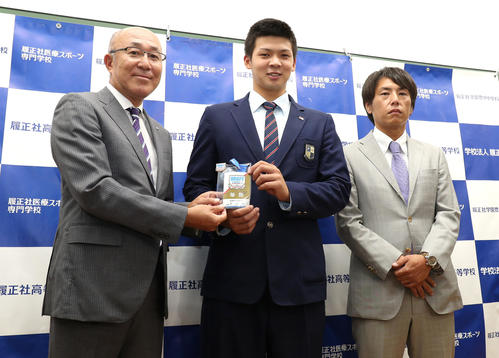 矢野燿大監督のサイン入りドラフトIDを畑山統括スカウト（左）から渡され笑顔を見せる履正社、井上広大（中央）右は渡辺スカウト（撮影・白石智彦）