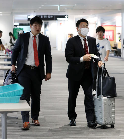 福岡空港から東京に向かう巨人丸（右）と岡本（撮影・垰建太）