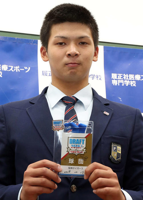 阪神矢野監督のサイン入りドラフトIDを手に取る履正社・井上（撮影・白石智彦）