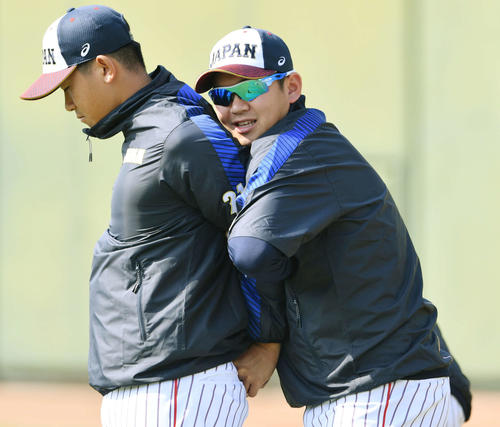 今永（左）のストレッチを手伝う山崎（撮影・滝沢徹郎）