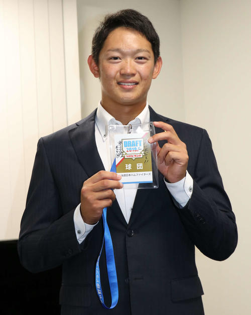 栗山英樹監督のサインとメッセージが添えられたドラフト会議の入館証を持つJX－ENEOS・鈴木（撮影・山崎純一）