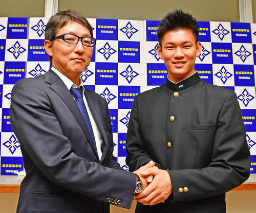 阪神の指名あいさつを受け吉野誠担当スカウト（左）と握手を交わすドラフト3位指名の横浜・及川雅貴（撮影・清水貴仁）