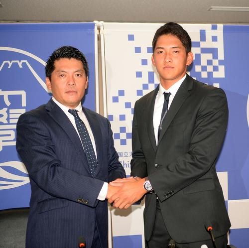 阪神から育成2位指名された静岡大の奥山外野手（右）は高山監督と握手する