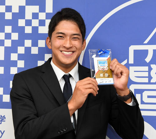 阪神の指名あいさつ受けた育成ドラフト2位の静岡大・奥山は、矢野監督のサイン入りドラフトIDを手に笑顔を見せる（撮影・前岡正明）