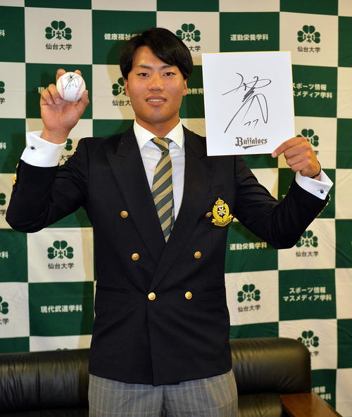 オリックス西村監督から贈られたサインボールと色紙を手に笑顔を見せる仙台大・佐藤