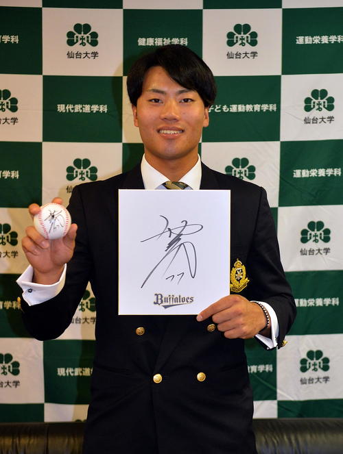 オリックス西村徳文監督から贈られたサインボールと色紙を手に笑顔を見せる仙台大・佐藤（撮影・鎌田直秀）
