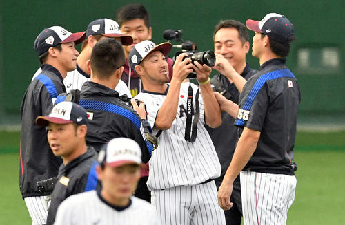 ウオーミングアップ中に西武秋山（右）の撮影をする広島菊池涼（右から3人目）（撮影・滝沢徹郎）