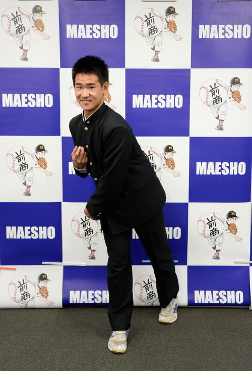 巨人ドラフト4位の前橋商・井上は指名あいさつを受け、同校出身の漫画家・あだち充氏のイラストパネルの前で笑顔でポーズ（撮影・鈴木正章）