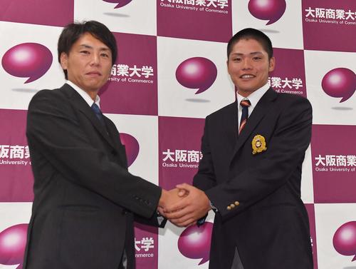 指名あいさつを受けた阪神育成ドラフト1位の大商大・小野寺暖は渡辺亮担当スカウトと笑顔で握手を交わす（撮影・上田博志）