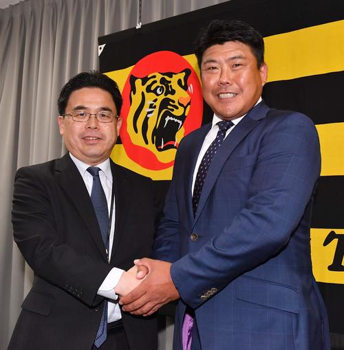 就任会見で阪神谷本修球団副社長（左）と握手を交わす北川博敏打撃コーチ（撮影・上田博志）