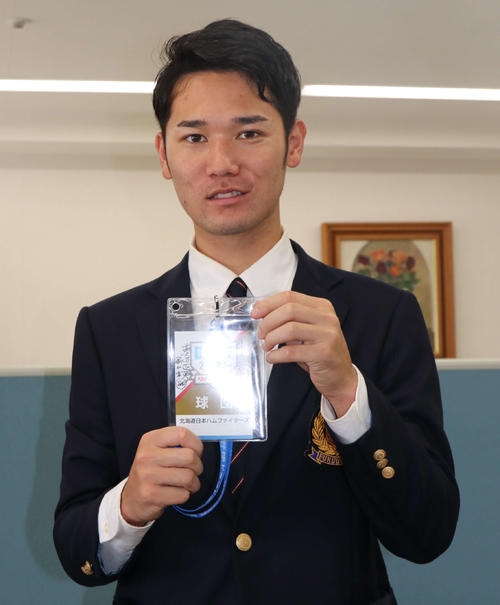 栗山英樹監督のサインとメッセージが添えられたドラフト会議のパスを持つ福岡大・宮田（撮影・山崎純一）