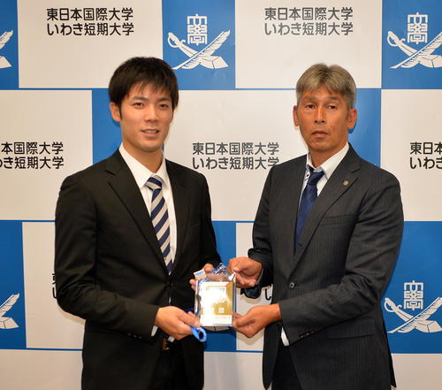日本ハム栗山英樹監督のメッセージが入ったドラフト会議のネームプレートを白井スカウト（右）から受け取る東日本国際大・片岡（撮影・鎌田直秀）