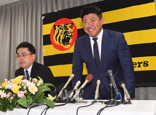 就任会見であいさつする北川コーチ。左は阪神谷本球団副社長（撮影・上田博志）