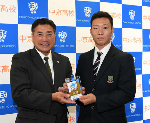 阪神にドラフト5位で指名された中京学院大中京の藤田（右）は、熊野担当スカウトから矢野監督のサイン入りドラフトIDを受け取る（撮影・前岡正明）