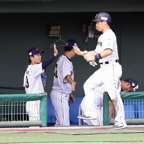 日本代表対オリックス　6回裏日本代表2死満塁、浅村の押し出し四球で生還した吉田正（右）をハイタッチで迎える山岡（撮影・浅見桂子）