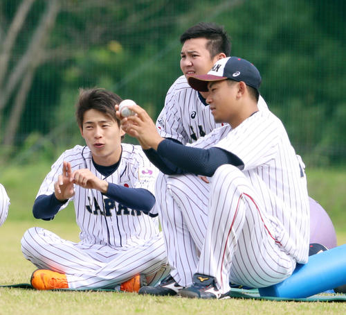 練習中、ボールの握り方について話す今永（右）と山岡（撮影・加藤哉）
