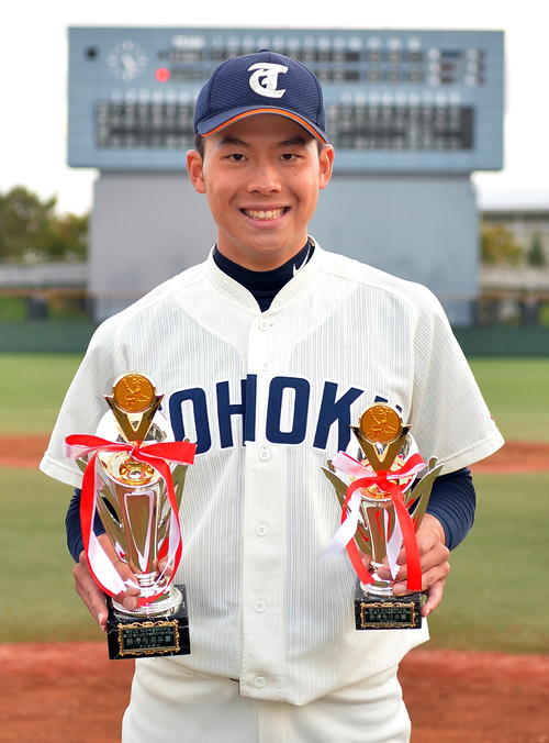 最優秀選手賞と最優秀投手賞のトロフィーを手に笑顔を見せる東北福祉大・綱脇（撮影・鎌田直秀）