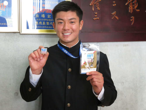 楽天からドラフト3位指名を受けた津留崎は石井GMのサインが入ったドラフトIDを受け取り笑顔（撮影・亀山泰宏）