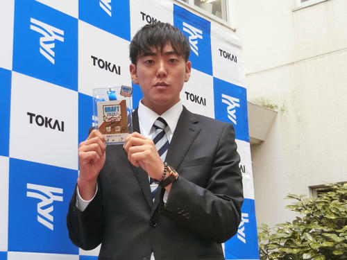 指名あいさつを受け、阪神矢野監督の直筆サインが書き込まれたドラフトIDを受け取った東海大九州・小川