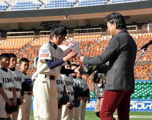 QVCマリンで行われたリアスリーグ決勝で優勝し、トロフィーを受け取る猪川小6年時の佐々木。右は総括プロデューサー山田氏（リアスリーグ実行委員会提供）