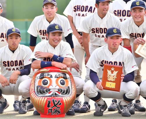神宮大会出場を決め必勝ダルマを手に笑顔を見せる大商大・小野寺（中央）と大西（右）（撮影・上田博志）