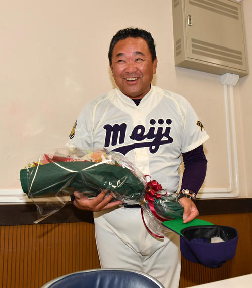 退任会見の後、担当記者から花束を贈られた明大・善波監督は笑顔で引き揚げる（撮影・柴田隆二）