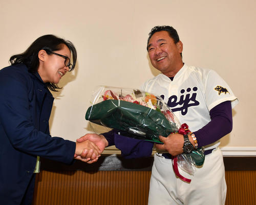 退任会見の後、担当記者から花束を贈られる明大・善波監督（右）（撮影・柴田隆二）