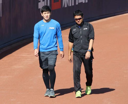 和田トレーナー（右）とともに球場の外野フェンス沿いをウオーキングする日本ハム野村（撮影・山崎純一）
