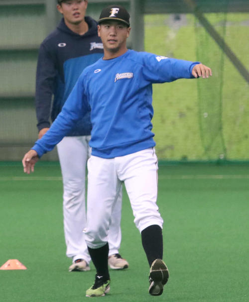 室内練習場でウオーミングアップをする日本ハム平沼（右手前）（撮影・山崎純一）