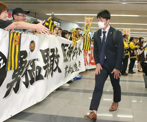 高知龍馬空港に到着した近本（右）はファンの温かい出迎えにお辞儀する（撮影・上山淳一）