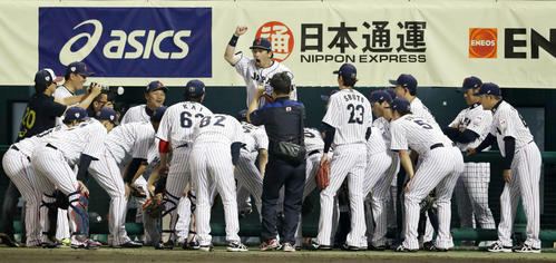 ベンチ前で円陣を組むナインの中心でジャンプする松田（撮影・加藤哉）