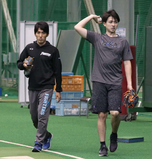 キャッチボールを終え、高橋知トレーナー（左）とともに室内練習場を引き揚げる日本ハム上沢（撮影・山崎純一）