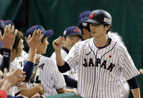 日本対カナダ　カナダに敗れ、残塁した日本周東（右）はベンチに戻りナインとタッチを交わす（撮影・垰建太）