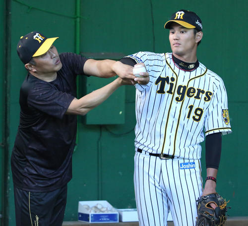 ブルペンで藤浪（右）を指導する山本昌臨時コーチ（撮影・上山淳一）