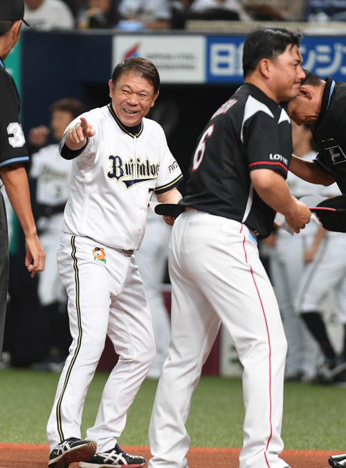 メンバー表交換で笑顔を見せるオリックス西村監督。右はロッテ井口監督（19年9月21日撮影）