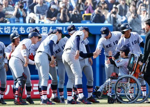 始球式を務めた田村君（右下）は慶大ナインに笑顔で出迎えられる（撮影・河田真司）