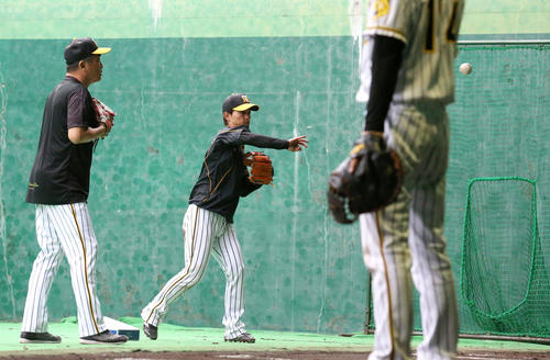 ブルペンで上本（右）を送球指導する山本昌臨時コーチ（撮影・上山淳一）