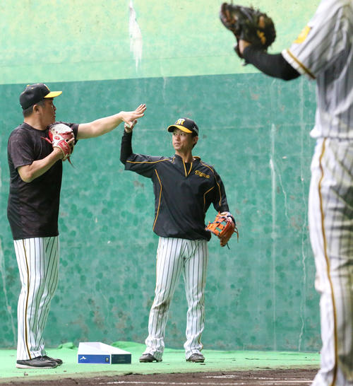 ブルペンで上本（右）を送球指導する山本昌臨時コーチ（撮影・上山淳一）