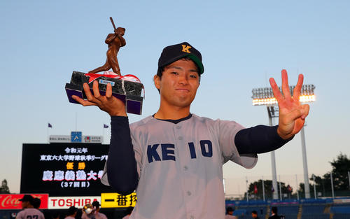 3冠獲得し3本指を立てる慶大・郡司は首位打者のトロフィーを掲げた（撮影・大野祥一）