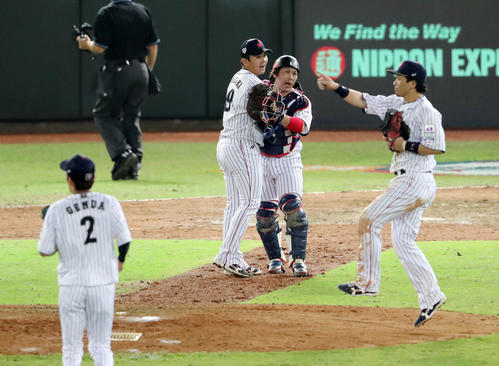 日本対ベネズエラ　ベネズエラに勝利し最後を締めた山崎（中央左）と甲斐は抱き合い喜ぶ（撮影・垰建太）