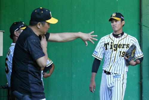 ブルペンで藤浪（右）を指導する山本昌臨時コーチ（撮影・上山淳一）
