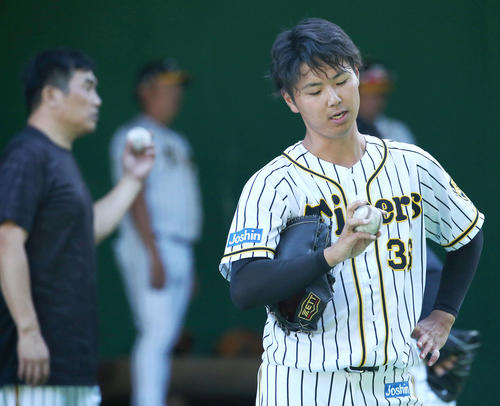 山本昌臨時コーチ（左）に教わった握りを確認する浜地（撮影・上山淳一）