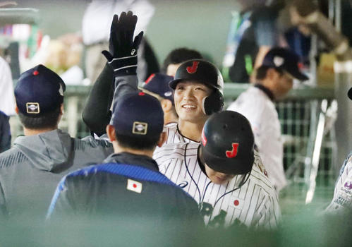 日本対ベネズエラ　5回裏日本1死一、二塁、中前適時打を放ち、攻守交代でベンチへ戻った鈴木はナインと笑顔でハイタッチする（撮影・加藤哉）