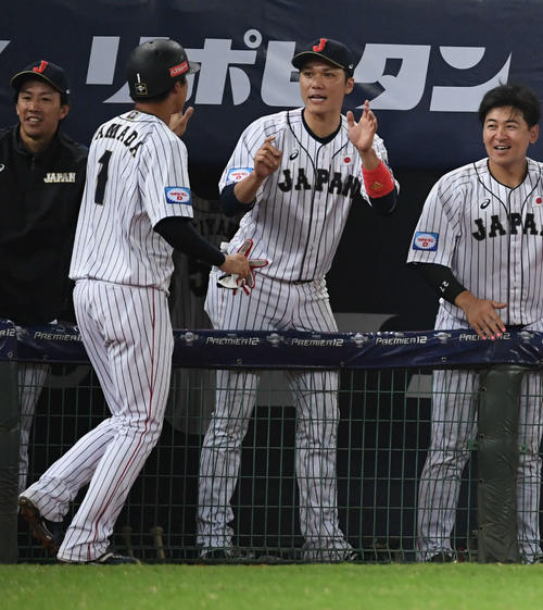 日本対ベネズエラ　8回裏日本1死満塁、坂本勇（中央）は鈴木の犠飛で生還した山田哲（左）とタッチをかわす。右は会沢（撮影・山崎安昭）