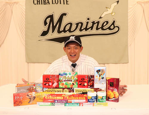 ロッテの菓子を前に笑顔のロッテ・ドラフト2位東洋大・佐藤（撮影・久永壮真）