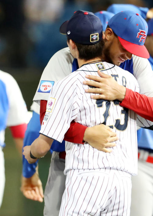 日本対プエルトリコ　試合前、ムニスと抱き合ってあいさつする周東（撮影・加藤哉）