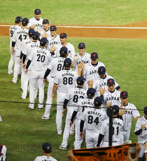 日本対プエルトリコ　プエルトリコに勝利し稲葉監督（中央）らナインと笑顔でタッチする高橋礼（撮影・加藤哉）
