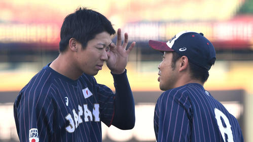 日本対台湾　試合前の練習中に山田哲（左）は目に入ったゴミを近藤に診てもらう（撮影・山崎安昭）